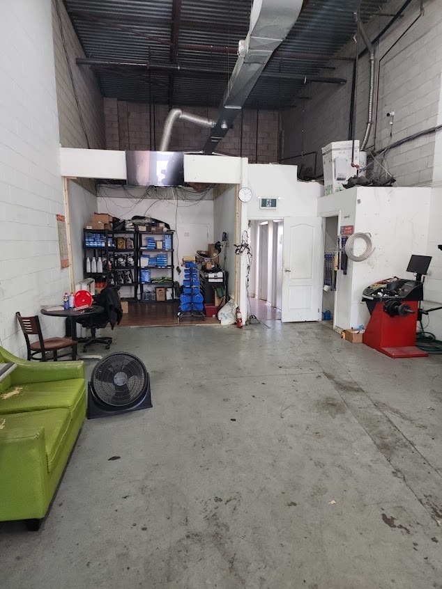The back of the shop: parts shelves, a fan and a couch