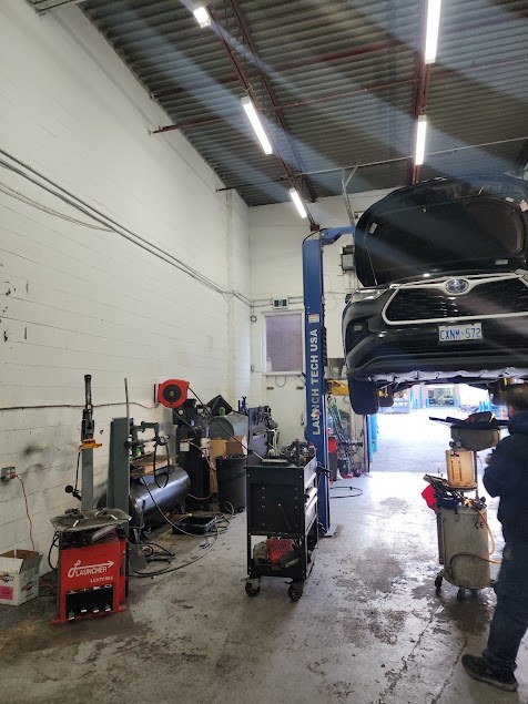 Looking into the bay: a car on the hoist and the tire machine
