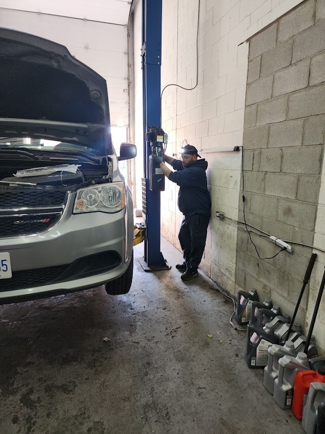 Kamal at the hoist with a Dodge Grand Caravan raised